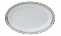 An empty porcelain oval plate from Philippe Deshoulieres Arcades Gold Dinnerware features a white center and a decorative rim with pale blue and gold accents.