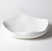 The Organic Round Bowl Matte White by Global Views/Surya, featuring a handcrafted, irregular shape, sits elegantly on a plain white surface.