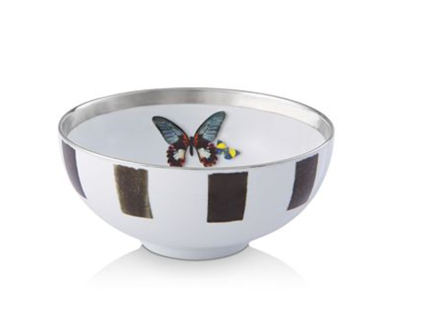 The Sol Y Sombra bowl by Christian Lacroix x Vista Alegre features a metallic-rimmed white exterior with vertical black rectangles and a colorful butterfly design inside.