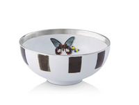 The Sol Y Sombra bowl by Christian Lacroix x Vista Alegre features a metallic-rimmed white exterior with vertical black rectangles and a colorful butterfly design inside.
