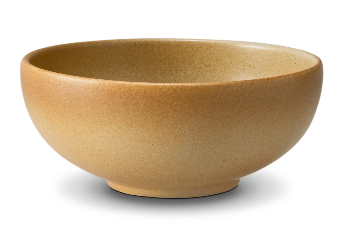 The L'Objet Terra Leather Dinnerware is a tan ceramic bowl with a speckled texture, shown in side view on a white background—an elegant, hand-crafted addition to your table.