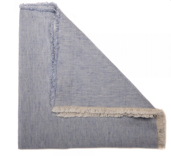 A folded Woven Washed Blue Fringe Napkin by Deborah Rhodes, featuring light blue prewashed linen with frayed edges, displays two layers with a corner turned up—reminiscent of their signature style.