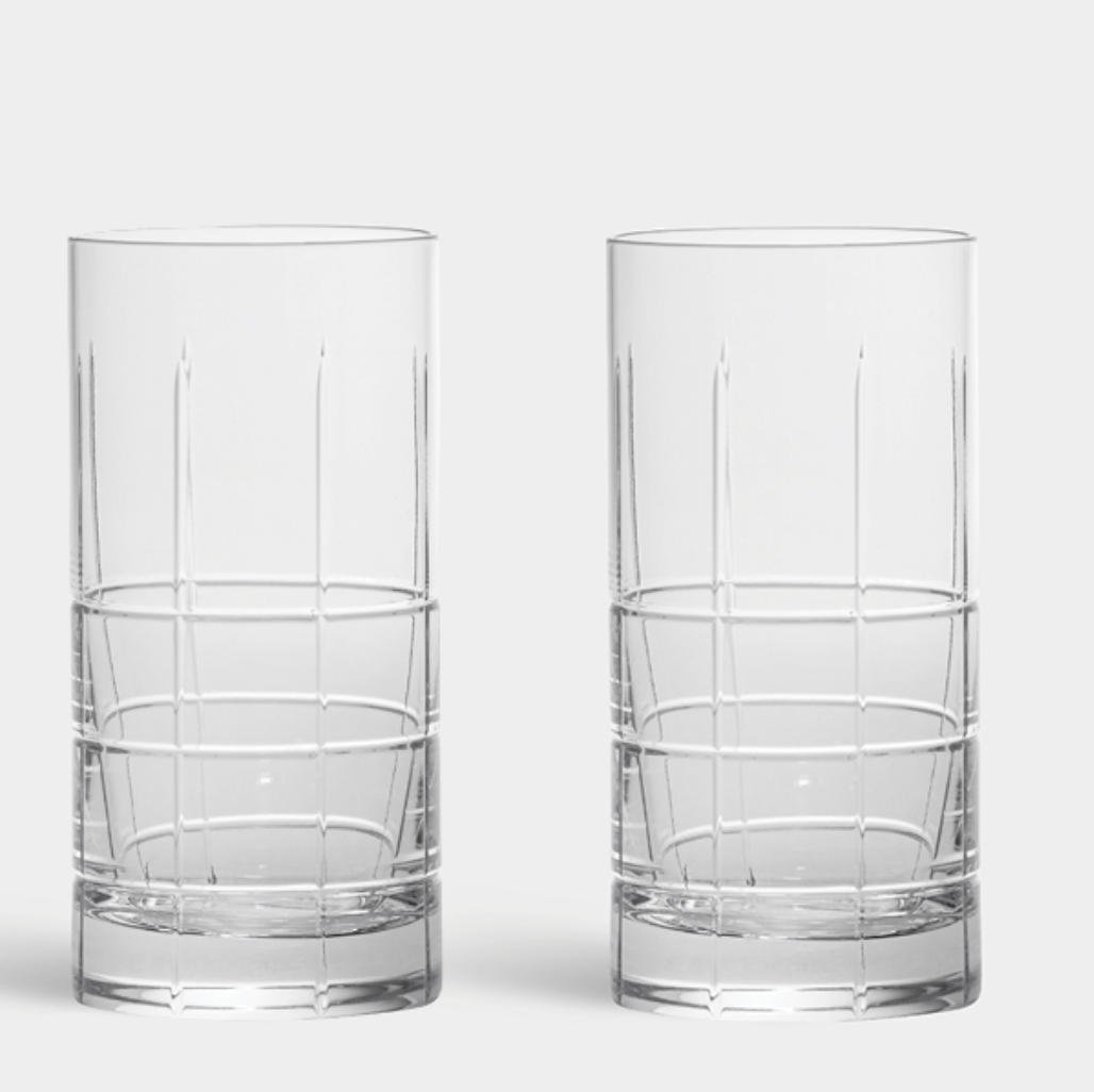 The Orrefors Kosta Boda Street Highball Glass Set of 2 features tall, clear glasses with vertical ribbing on the upper half and a grid pattern at the base.