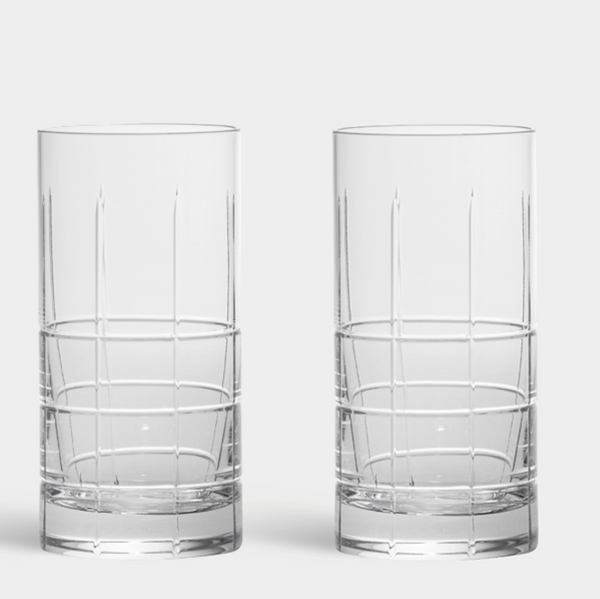 The Orrefors Kosta Boda Street Highball Glass Set of 2 features tall, clear glasses with vertical ribbing on the upper half and a grid pattern at the base.