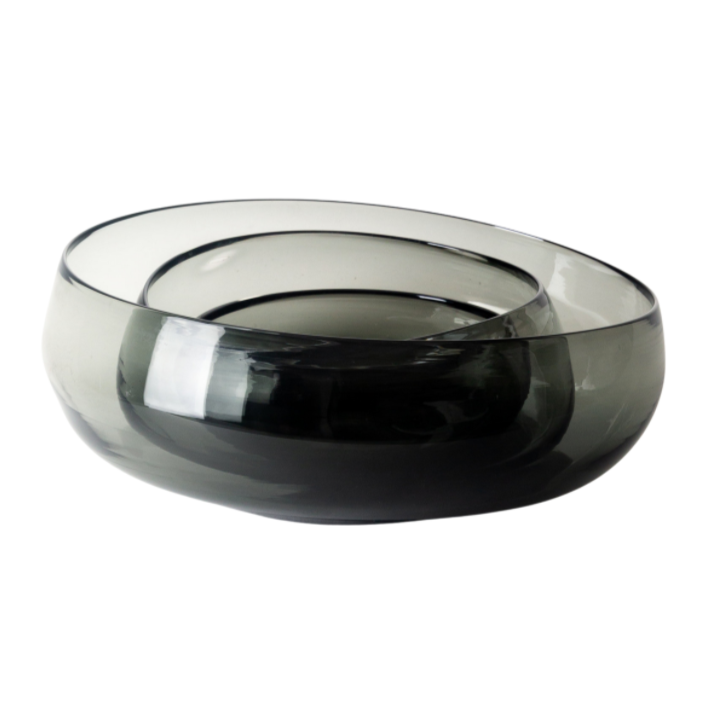 The Gary Bodker Nesting Glass Bowl Charcoal features hand-blown, dark gray glass with smooth, rounded edges and an asymmetrical form, showcasing modern elegance against a white background.