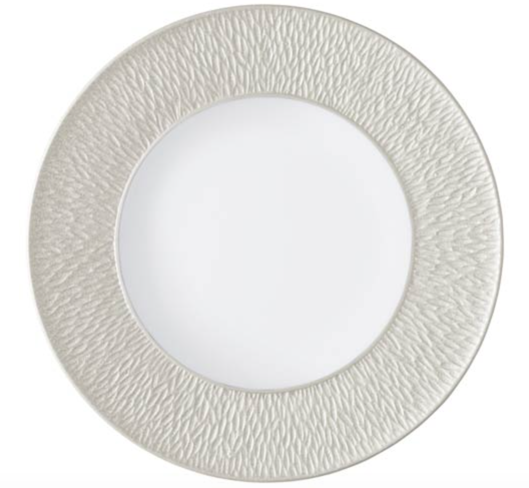 The Raynaud Mineral Irise Dinnerware Pearl Grey is a round, white Limoges porcelain plate with a smooth center and a wide, subtly wavy textured light gray rim.