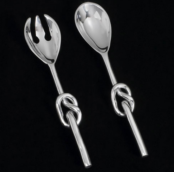 The Knotty Salad Set by Inspired Generations features a fork and spoon, each handcrafted from polished aluminum with twisted knot handles, beautifully displayed on a black background.