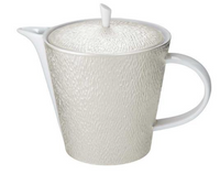 The Raynaud Mineral Irise Dinnerware Pearl Grey teapot features a textured, pearl grey ceramic body with a round lid, short spout, and large curved handle. Its subtle raised pattern evokes classic French Limoges porcelain.