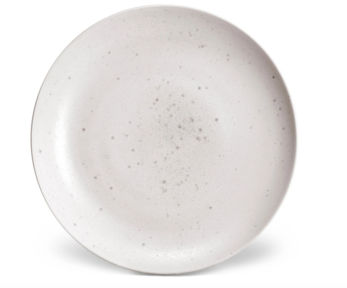 The L'Objet Terra Stone Dinnerware plate features a round shape, light gray matte finish, and subtle speckles, reflecting handcrafted elegance. Photographed from above on a white background.