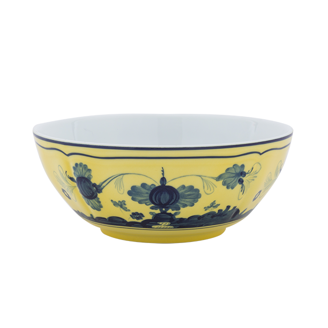 The Oriente Italiano Dinnerware Citrino by Ginori 1735 is a round porcelain bowl with a yellow exterior and blue chinoiserie floral motifs. Its interior is white, set against a plain white background.