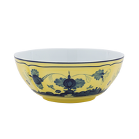 The Oriente Italiano Dinnerware Citrino by Ginori 1735 is a round porcelain bowl with a yellow exterior and blue chinoiserie floral motifs. Its interior is white, set against a plain white background.