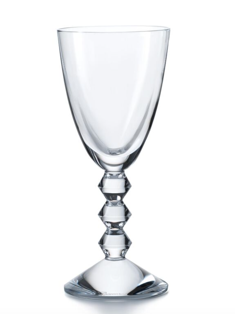 The Baccarat Vega White Wine Glass features a clear, faceted design with a geometric diamond-shaped stem and wide bowl, showcased against a plain white background.