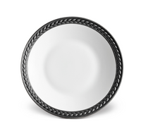 The Soie Tressée Black Dinnerware by L'Objet is a round, white luxury porcelain plate featuring a dark braided rim pattern, shown from above on a white background.
