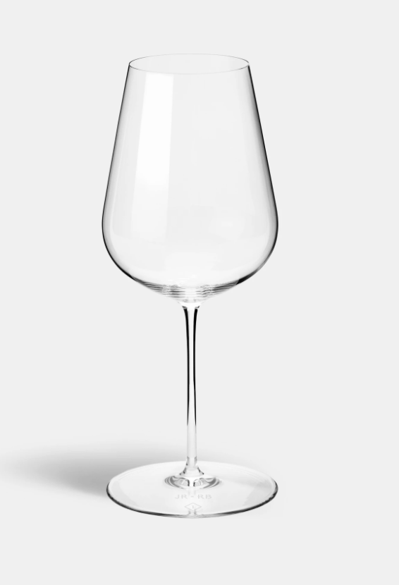 A set of two clear, empty Jancis Robinson Universal Wine Glasses by Richard Brendon, each with a long stem and wide rounded bowl, stands upright against a plain light gray background.