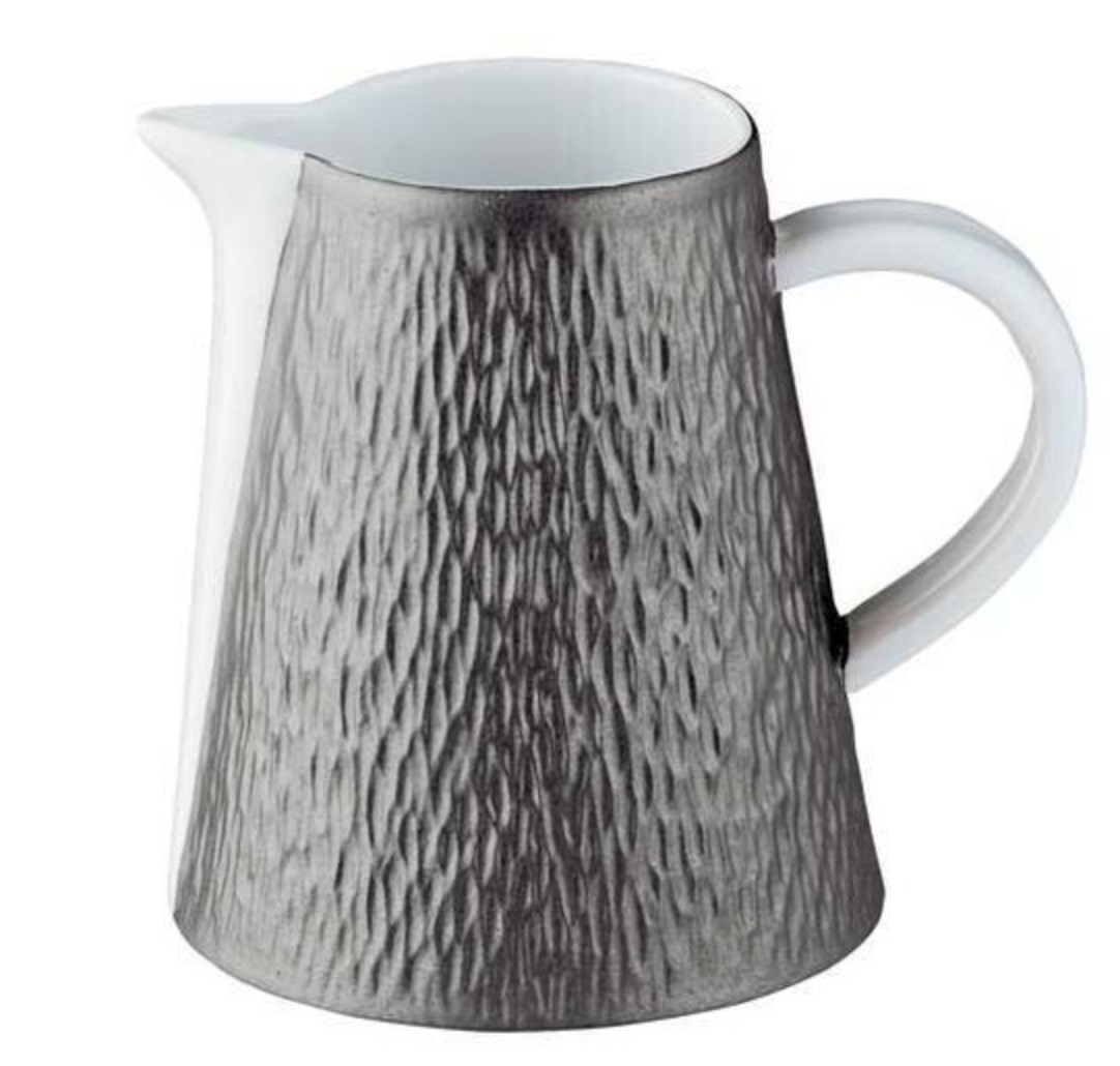 The Mineral Irise Dinnerware Dark Grey by Raynaud is a ceramic pitcher with a textured dark gray exterior, smooth white interior and handle, and a small spout—crafted in France with classic Limoges porcelain artistry.