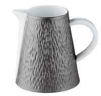 The Mineral Irise Dinnerware Dark Grey by Raynaud is a ceramic pitcher with a textured dark gray exterior, smooth white interior and handle, and a small spout—crafted in France with classic Limoges porcelain artistry.