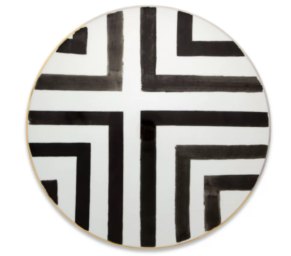 The Sol Y Sombra charger by Christian Lacroix x Vista Alegre features bold, geometric black lines on white porcelain—a striking, modern accent to elevate your Vista Alegre dinnerware collection.