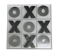 The Eye Candy Marble & Silver Acrylic Tic Tac Toe Set features a clear acrylic board with mirrored marble X and O pieces; Xs fill the top center, middle left, middle right, and bottom center squares, while Os take the other spots.