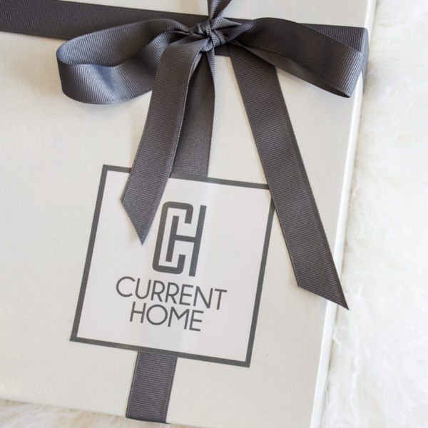 A white GIFT PRESENTATION box by Nulls.Net features a gray ribbon bow and a modern black label. The box is set on a fluffy white surface.