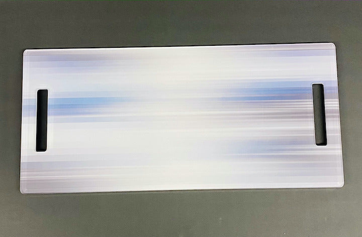 The Eye Candy Serving Long Board | Blurred Lines is a rectangular, slightly iridescent acrylic board with two hand slots and a blue-white gradient, ideal as a serving platter for your kitchen island.