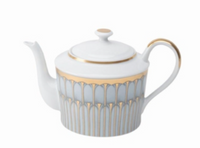 A white porcelain teapot from Philippe Deshoulieres’ Arcades Gold Dinnerware features gold and gray geometric patterns, a gold-rimmed lid, and a gold-accented handle, shown on a plain white background.