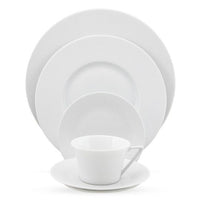 The Seychelles Dinnerware by Philippe Deshoulieres features a white teacup with saucer, small, medium, and large plates, all stacked by size against a white background.