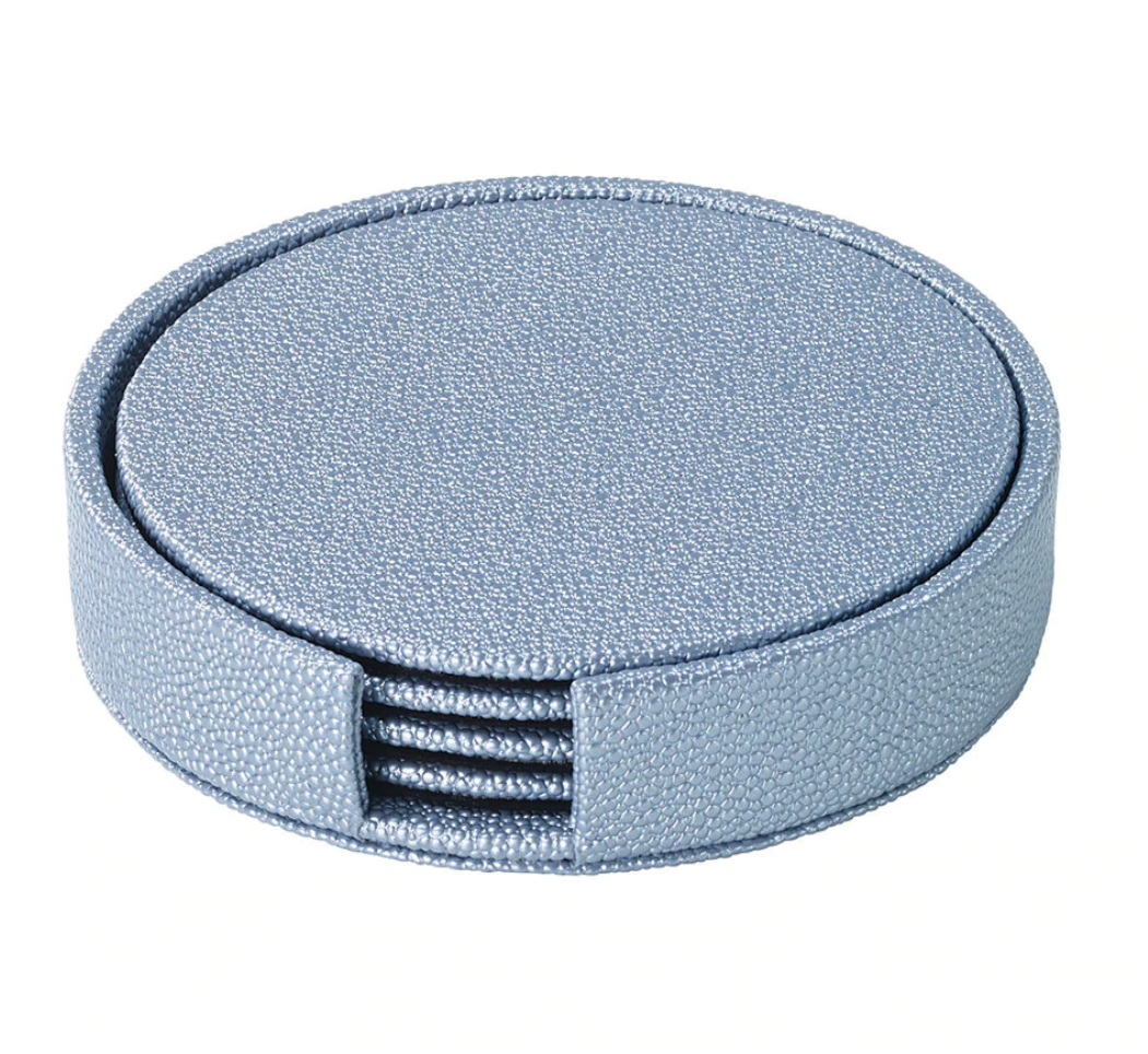 The Bodrum Skate Coaster Set of 4 features round, textured light blue phthalate-free vinyl coasters in a matching holder with a side opening, revealing the neatly stacked coasters inside.