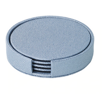 The Bodrum Skate Coaster Set of 4 features round, textured light blue phthalate-free vinyl coasters in a matching holder with a side opening, revealing the neatly stacked coasters inside.