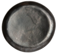 The Marcus Black Dinnerware Set of 4 by Blue Pheasant features round, dark gray stoneware plates with a subtly uneven surface and minor indentations, highlighting the brand’s signature organic silhouettes. Shown on a white background.