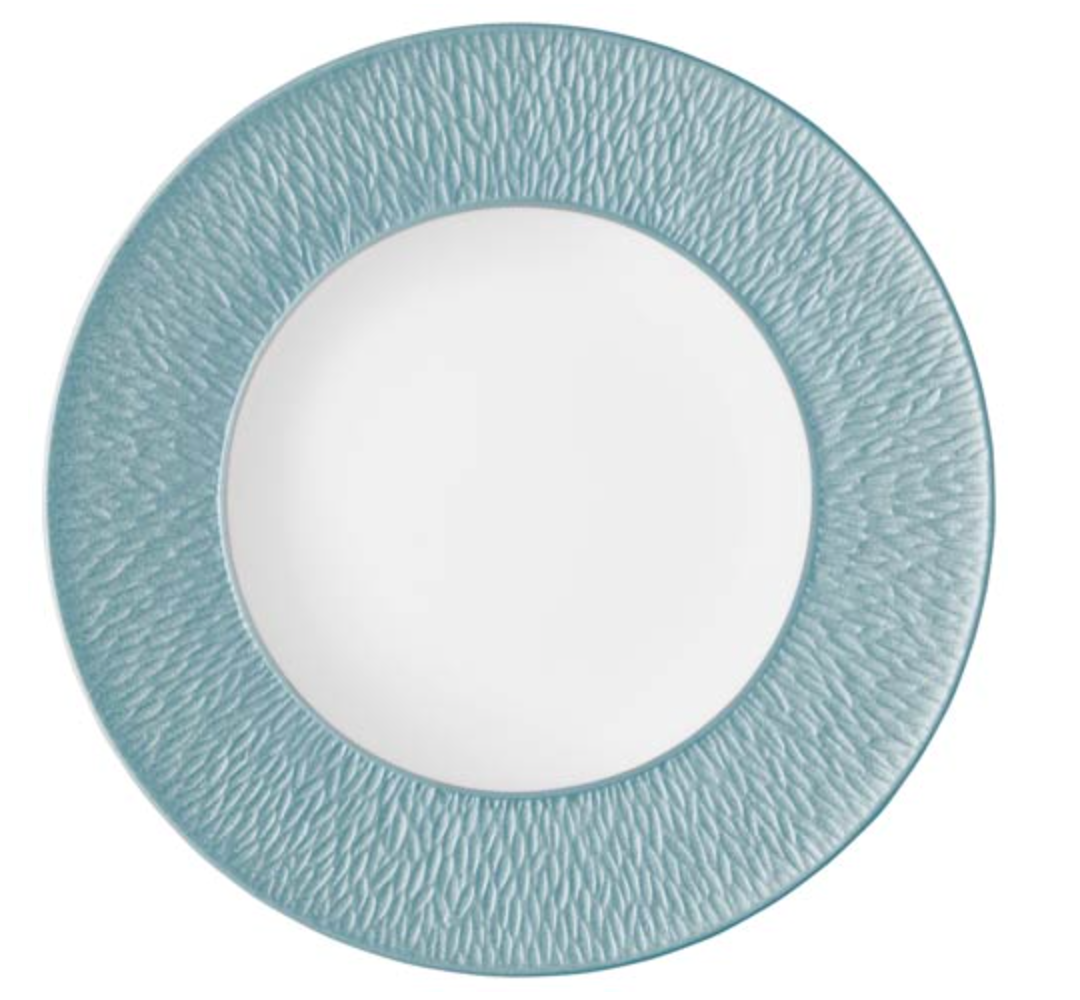 The Raynaud Mineral Irise Dinnerware Sky Blue plate, crafted in France, features a textured teal-blue rim and smooth white center—an elegant modern addition to your table.