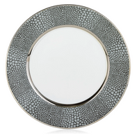 The Makassar Gray & Platinum Dinnerware by Royal Limoges/Bia Cordon Bleu features a round ceramic plate handmade in France, with a plain white center, wide textured gray rim with small spots, and thin platinum bands for an elegant touch.