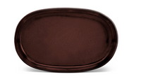 The Terra Wine Dinnerware by L'Objet is a large, oval-shaped, dark brown ceramic plate with a glossy finish, handcrafted and displayed on a plain white background.