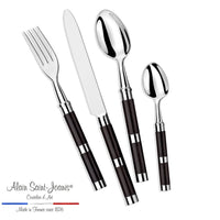 The Alain Saint-Joanis Carla Flatware Ebony 5 Piece Setting features hand-polished stainless steel utensils with dark handles, arranged side by side. Logo text: Alain Saint-Joanis flatware, hand-polished in France since 1876.