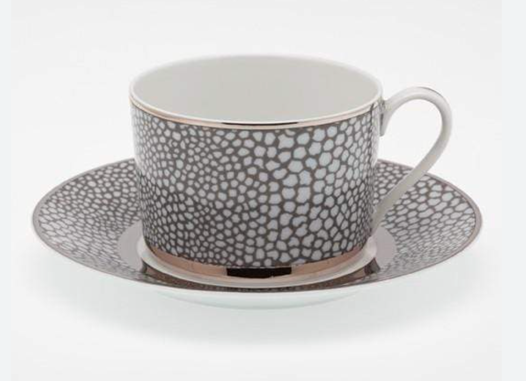 The Makassar Gray & Platinum Dinnerware by Royal Limoges/Bia Cordon Bleu features handmade French porcelain teacups and saucers with a white interior, textured black and white spotted exterior, and elegant platinum trim.