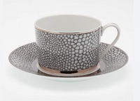 The Makassar Gray & Platinum Dinnerware by Royal Limoges/Bia Cordon Bleu features handmade French porcelain teacups and saucers with a white interior, textured black and white spotted exterior, and elegant platinum trim.