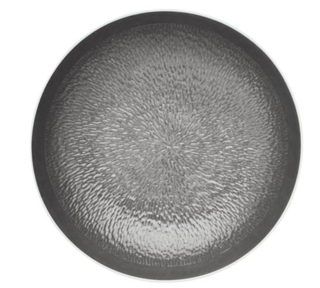 The Mineral Irise Dinnerware Dark Grey by Raynaud is a round, textured plate in dark gray, viewed from above, with a subtle radiating pattern for a slightly reflective, tactile look—an elegant piece of dinnerware.