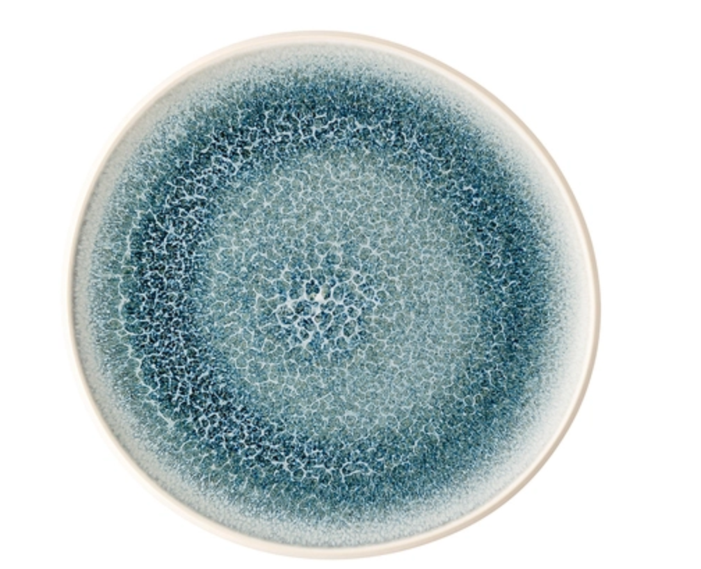 The Rosenthal Junto Aquamarine Dinnerware plate features a round stoneware design with a blue and white crackle glaze gradient radiating from the center and an off-white rim. Dishwasher and microwave safe.