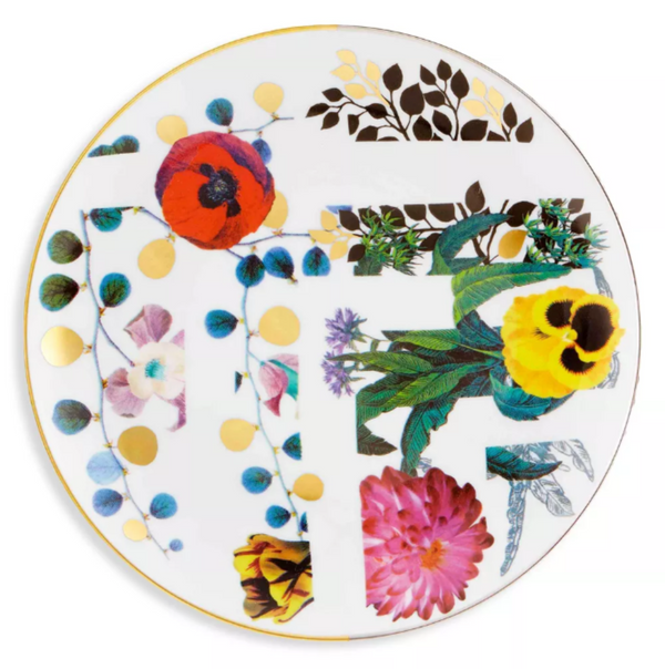 The Primavera Serving Pieces by Vista Alegre are round white porcelain dessert plates, featuring a gold rim and adorned with colorful flowers, green leaves, gold dots, and abstract black and gold branch patterns for a modern artistic look.