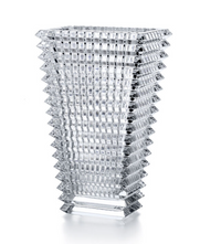 The Baccarat Eye Rectangular Vase Clear features a geometric design with a square base, a flared top, and textured raised squares creating a striking grid-like pattern along its sides.