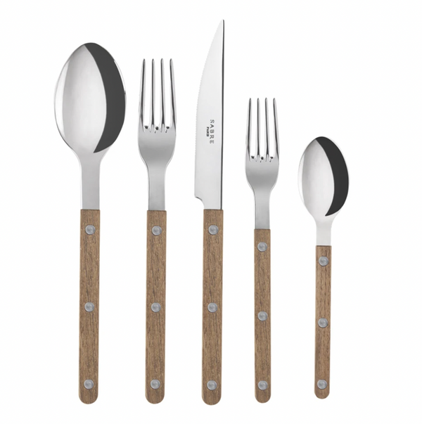 The Sabre Bistro Flatware 5 Piece Setting -Teak includes a large spoon, large fork, knife, small fork, and small spoon with polished stainless steel tops and teak handles with three rivets, shown arranged on a white background.