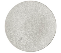 The Mineral Irise Dinnerware Pearl Grey by Raynaud is a round, pearl grey Limoges porcelain plate with a textured surface featuring a fine, radiating pattern of small, overlapping ridges.