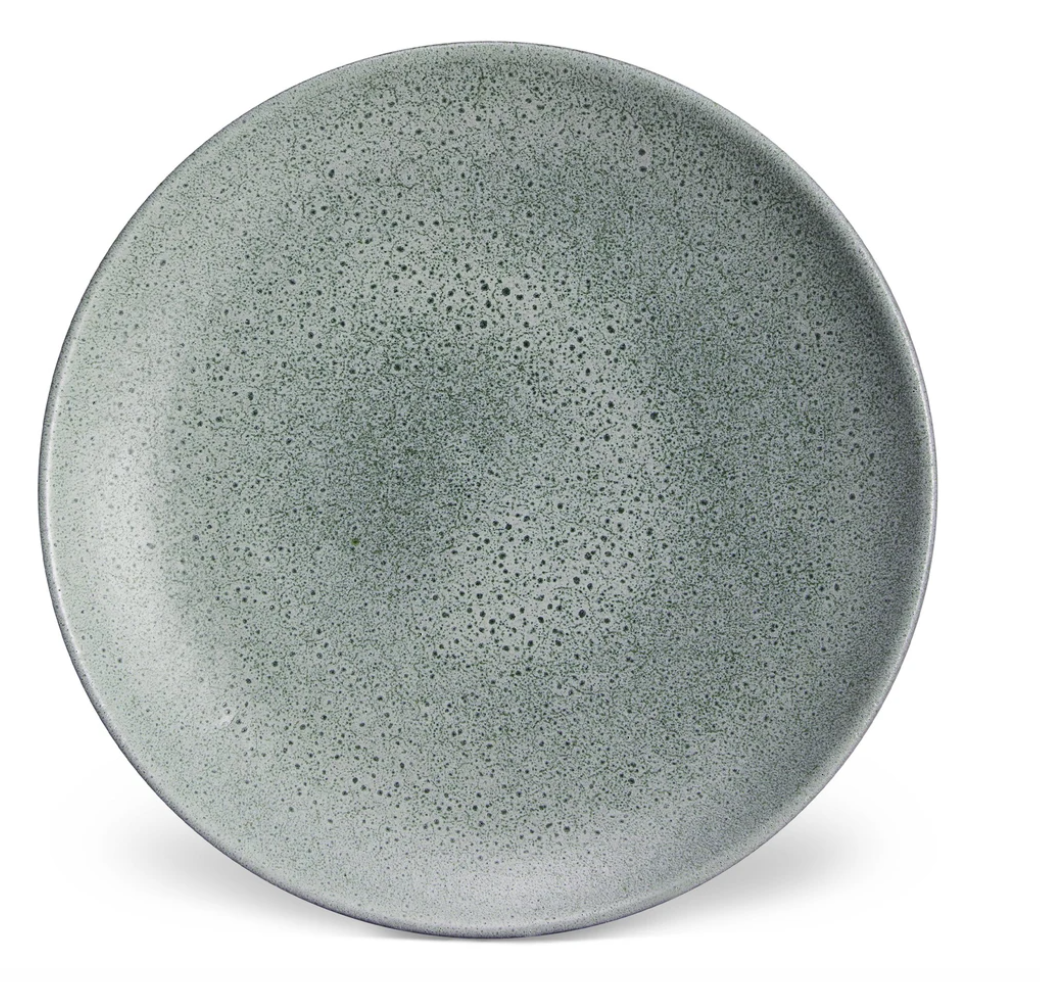 A round, speckled grey plate with a matte finish from L'Objet’s Terra Seafoam Dinnerware collection, featuring exquisite handcrafted design.