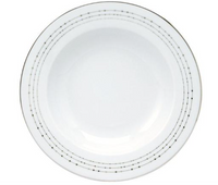 The Carrousel Dinnerware by Philippe Deshoulieres is a white ceramic plate with a slightly raised rim and thin dotted lines circling the edge, evoking the elegance of platinum-trimmed dinnerware.