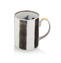 The Sol Y Sombra mug by Christian Lacroix x Vista Alegre features vertical black brushstroke stripes on white ceramic, a metallic silver handle with a gold accent, and a blue design inside—echoing the brand's signature artistry.