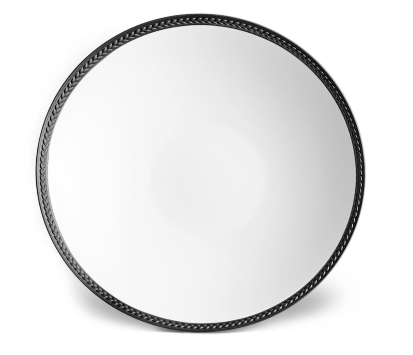 A round, reflective mirror with a black, braided-pattern frame inspired by L'Objet's Soie Tressée Black Dinnerware, photographed against a white background.