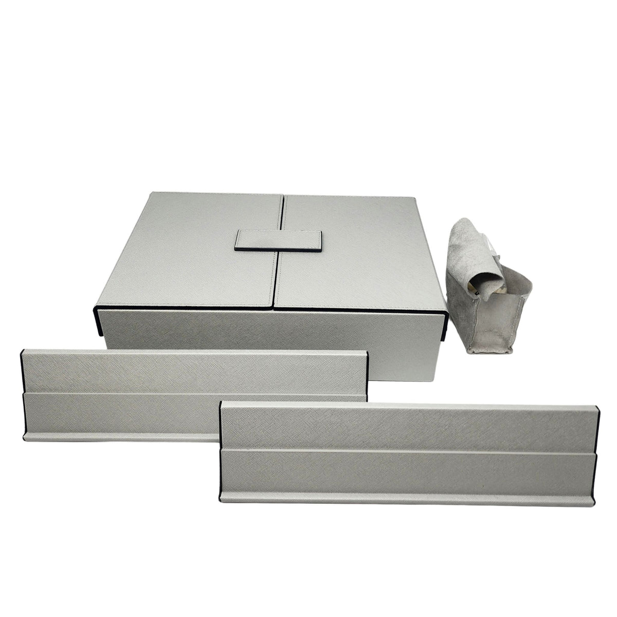 The Brouk & Co Excelsior Rummikub Set Silver features light gray rectangular storage boxes and trays with black edges—a large leather lidded box, two slim trays, and a rolled-up pouch—all displayed on a white background.