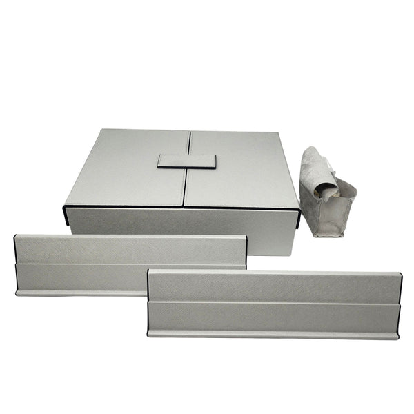 The Brouk & Co Excelsior Rummikub Set Silver features light gray rectangular storage boxes and trays with black edges—a large leather lidded box, two slim trays, and a rolled-up pouch—all displayed on a white background.