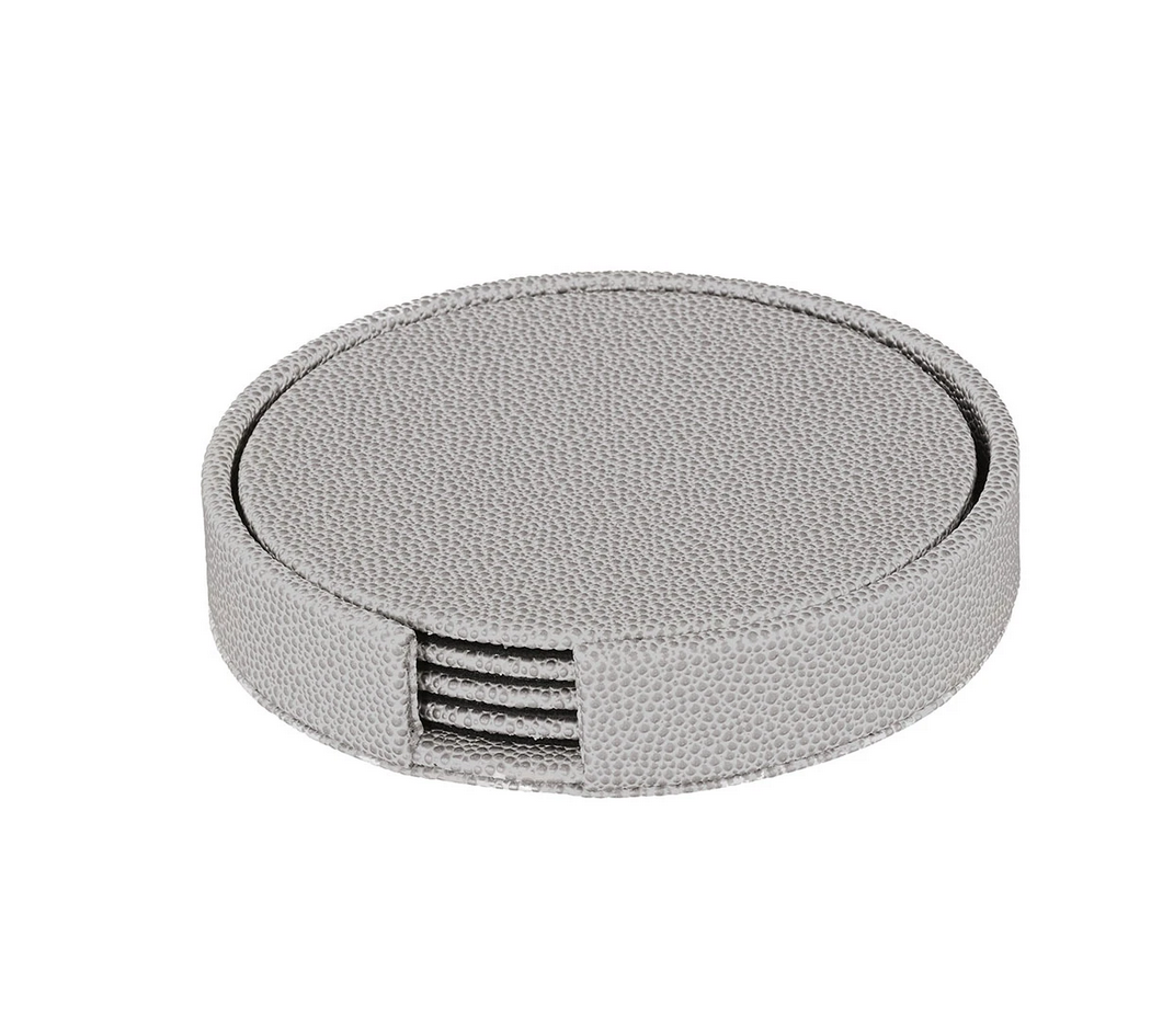 The Bodrum Skate Coaster Set of 4 features phthalate-free vinyl coasters in a round, light gray textured holder with an open slot in front to display the stacked coasters inside.