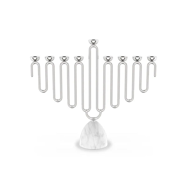 The Coluna Menorah Carrara Marble & Silver by Anna New York features a striking geometric, wavy design with eight silver branches set atop a smooth Italian Carrara marble base. Photographed against a plain white background, this modern menorah seamlessly blends contemporary style with timeless elegance.