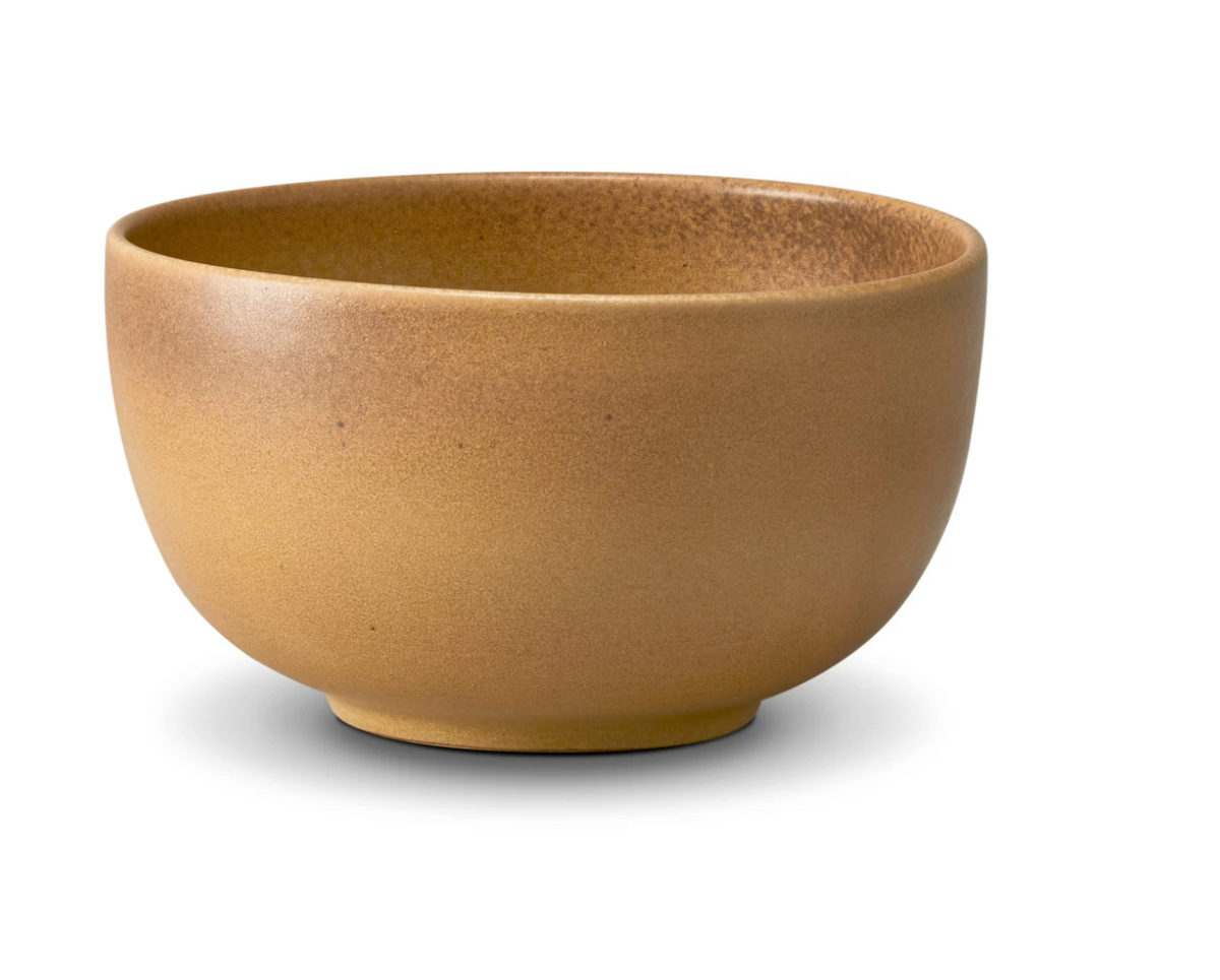 The Terra Leather Dinnerware by L'Objet—a brown ceramic bowl with a matte finish—rests on a white background, its soft shadow highlighting the hand-crafted design.